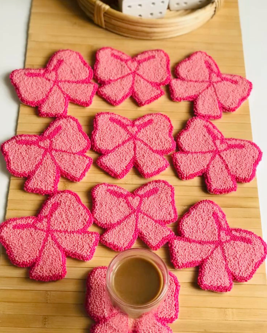 Porta-copos em formato de laço rosa feitos com bordado russo